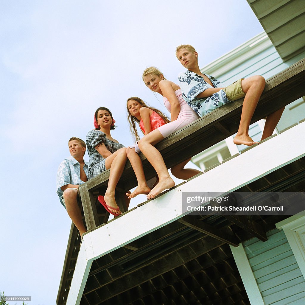 Young people sitting on balcony, low angle view
