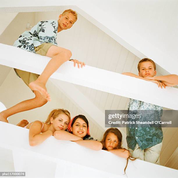 five teenagers in loft looking into camera, low angle view - balustrade stock pictures, royalty-free photos & images