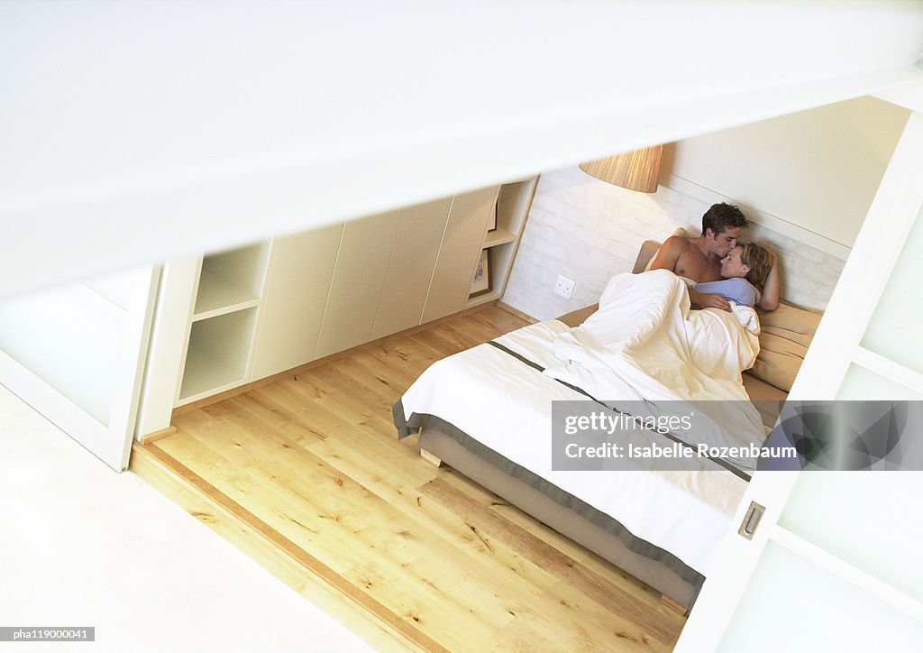 Couple in bed, embracing, high angle view