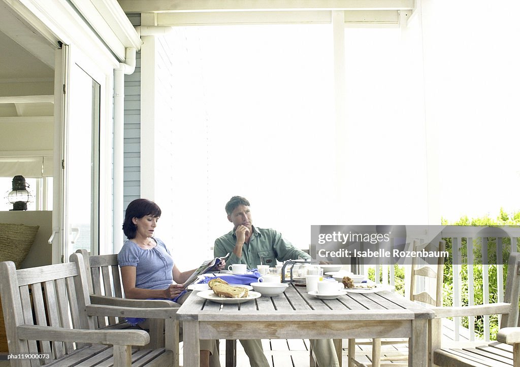 Couple sitting at table, outside