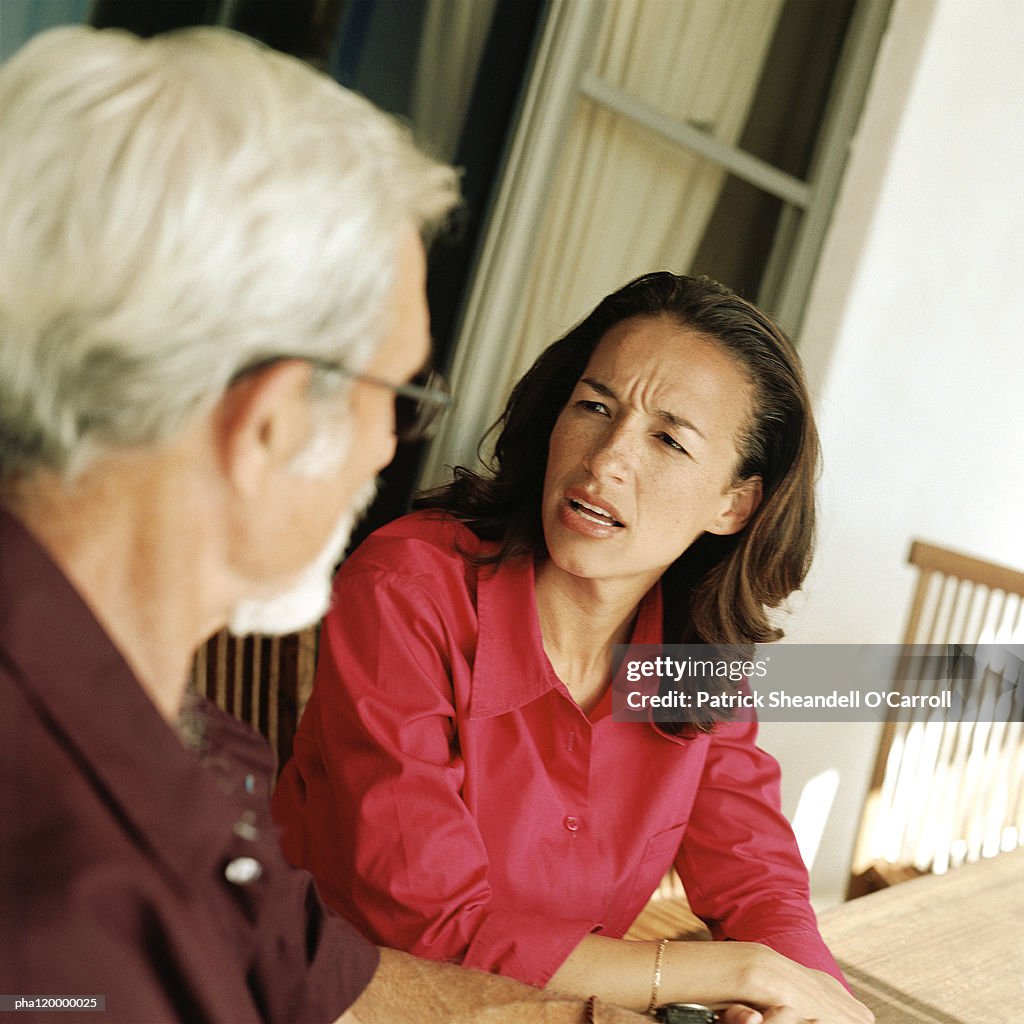 Woman speaking with senior man