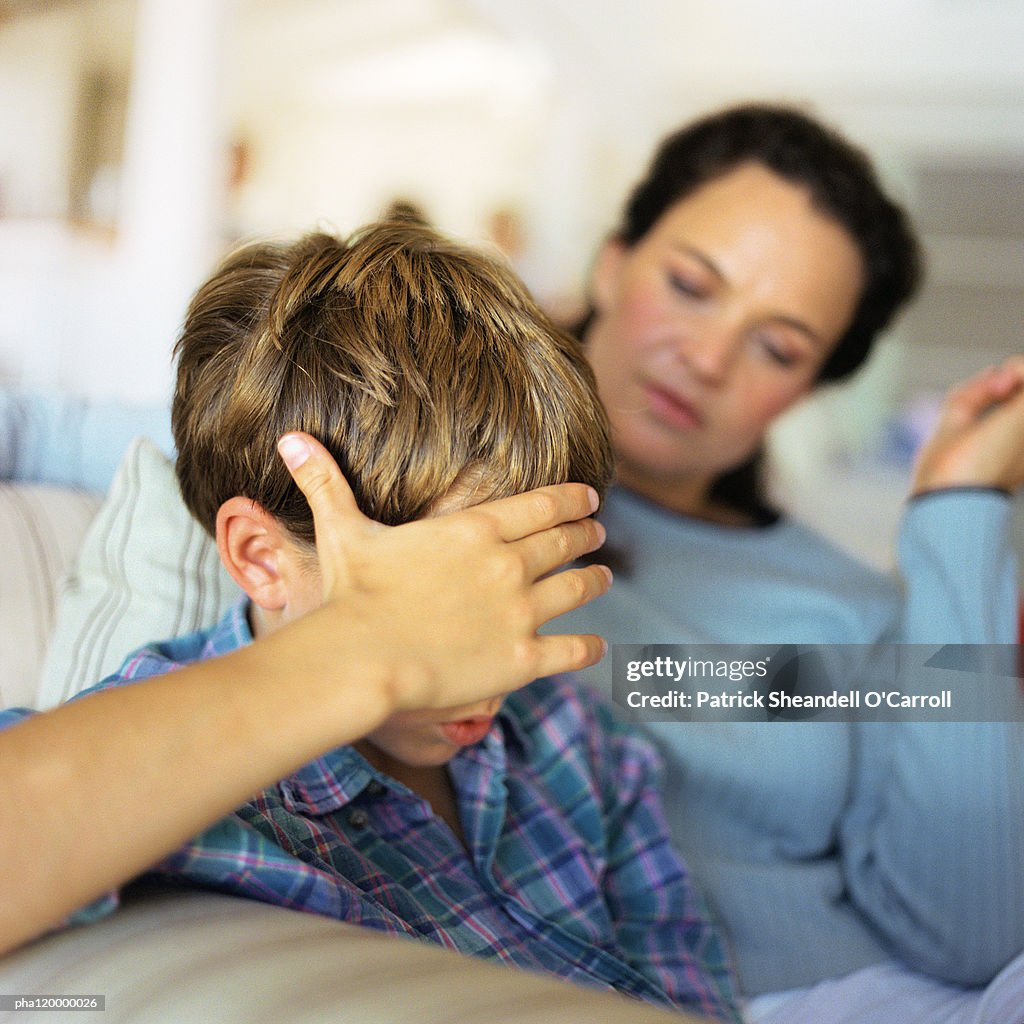 Woman and child with hand on head