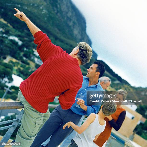 people holding glasses, man leaning on railing - balustrade stock pictures, royalty-free photos & images