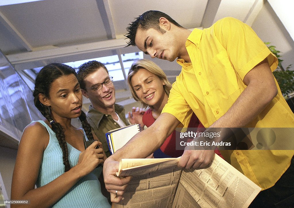 Two men and two women examining document