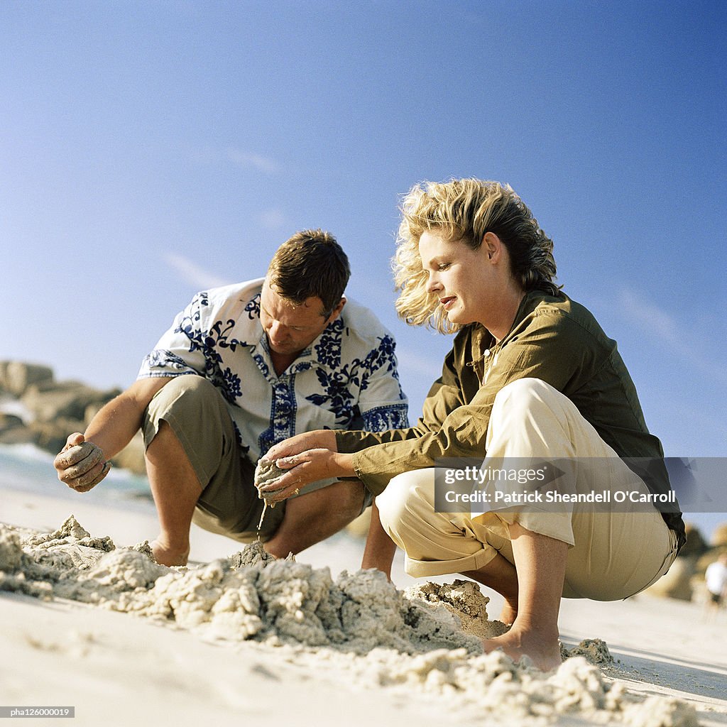 Mature couple digging in sand