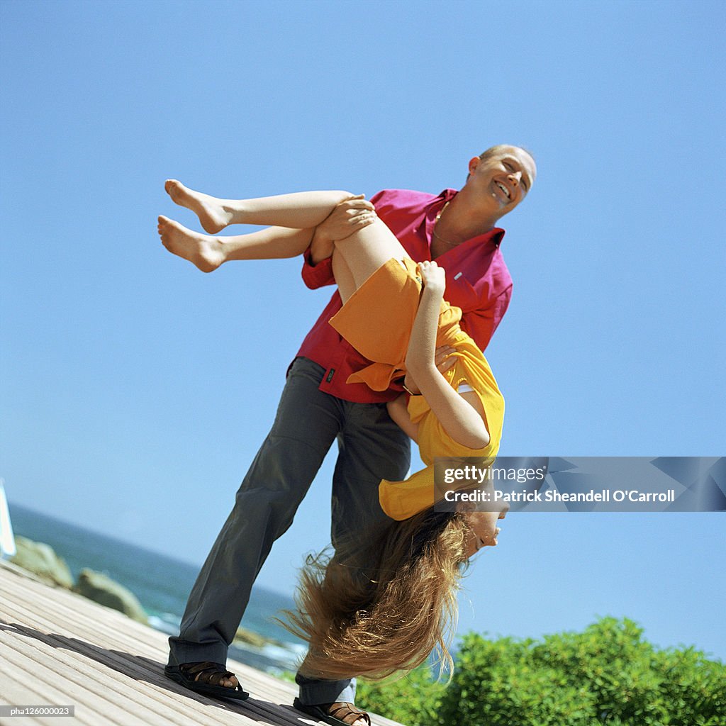 Father carrying daughter, outside