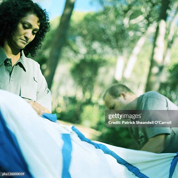 mature couple in forest, woman setting up tent - installation of memorial honors victims of ghost ship fire in oakland stockfoto's en -beelden