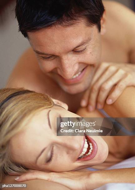 couple laying on bed, smiling - clara stock pictures, royalty-free photos & images