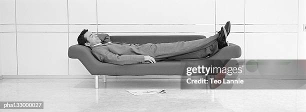 businessman lying on a sofa, profile, b&w - suit and tie stock pictures, royalty-free photos & images