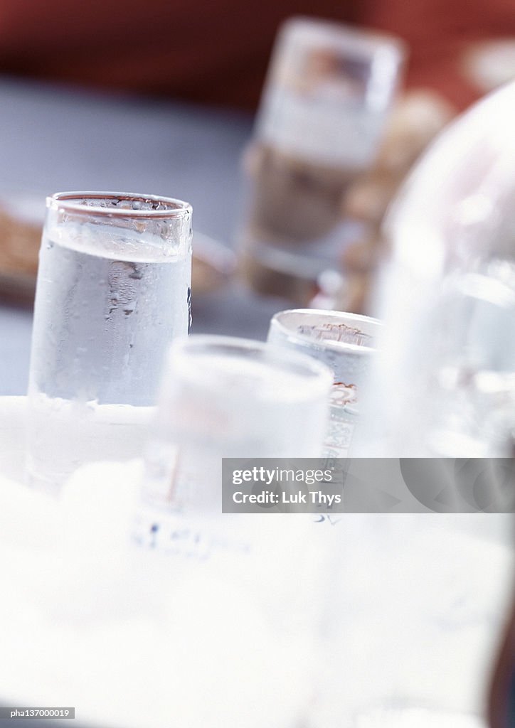 Four glasses of clear alcohol.