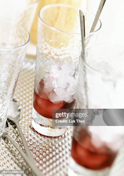 two glasses half filled with red liquid and crushed ice. - künstliches eis stock-fotos und bilder