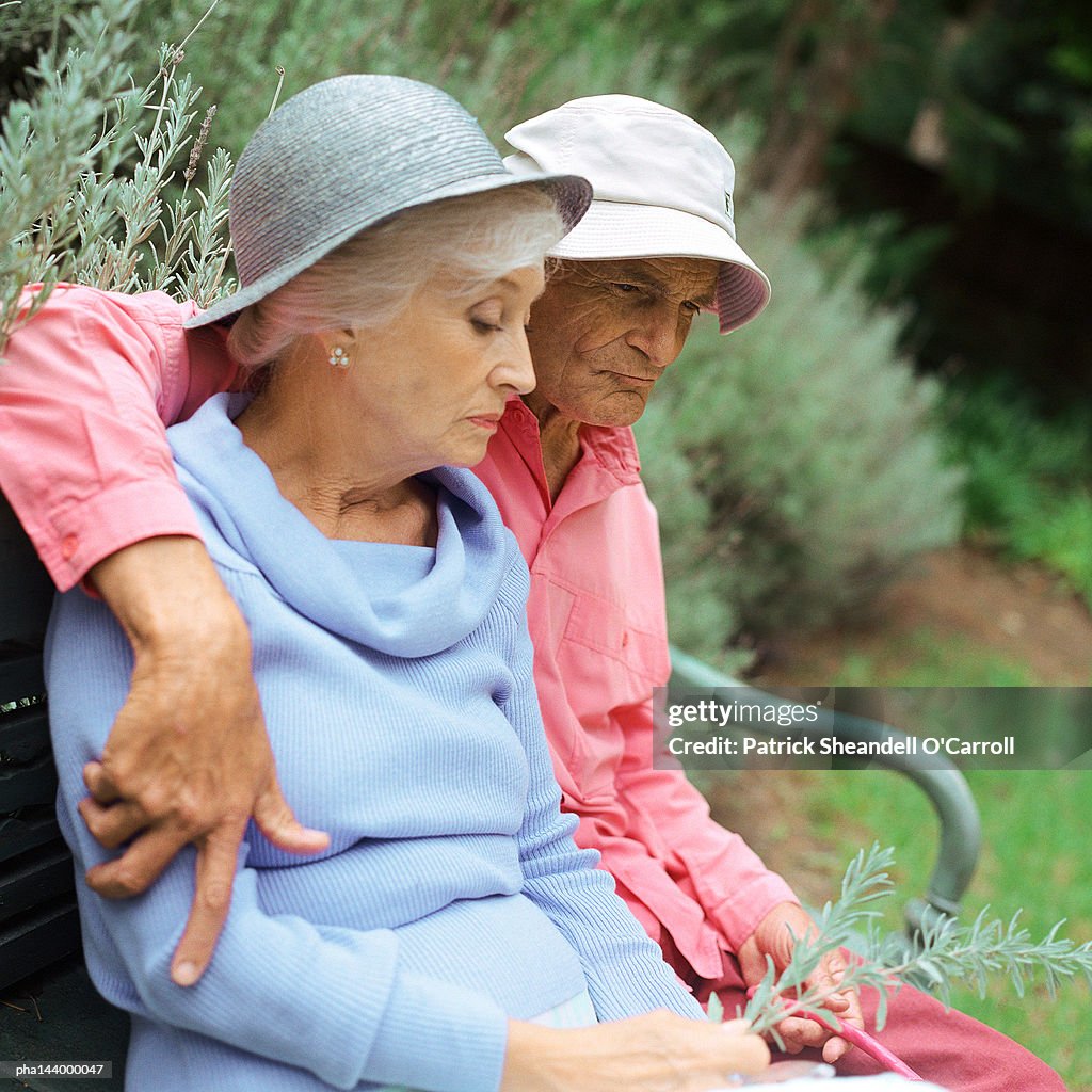 Mature couple sitting on bench outside