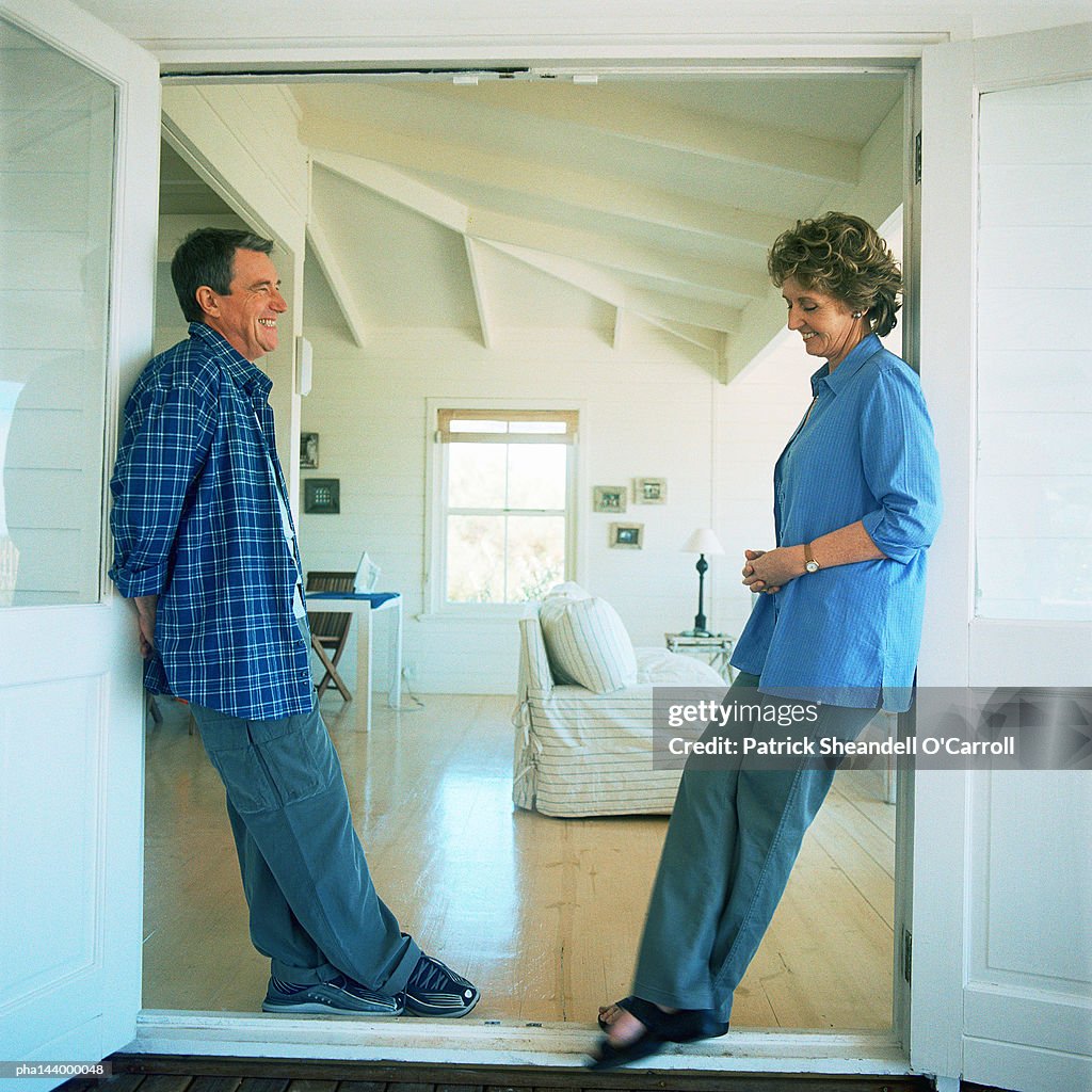 Mature man and woman standing face to face, smiling