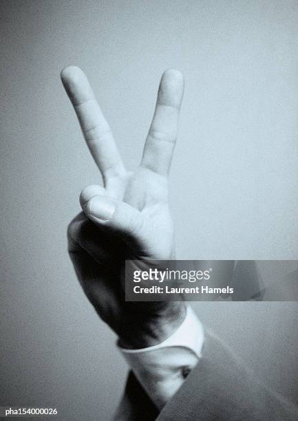 hand making victory sign, b&w. - w hand sign stock pictures, royalty-free photos & images