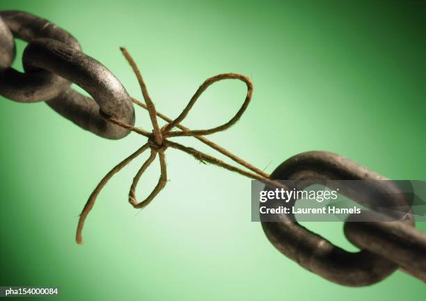 two ends of a chain linked by string, close-up. - faiblesse photos et images de collection