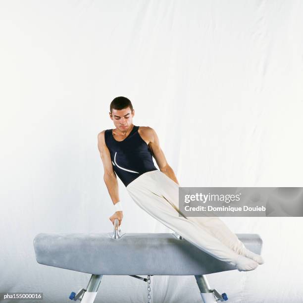 male gymnast performing routine on pommel horse. - gymnast stock pictures, royalty-free photos & images