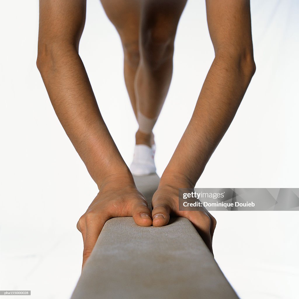 Female gymnast on balance beam, close-up.