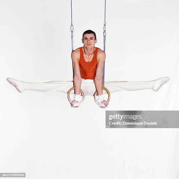 male gymnast performing on rings. - turnringe-turngerät stock-fotos und bilder