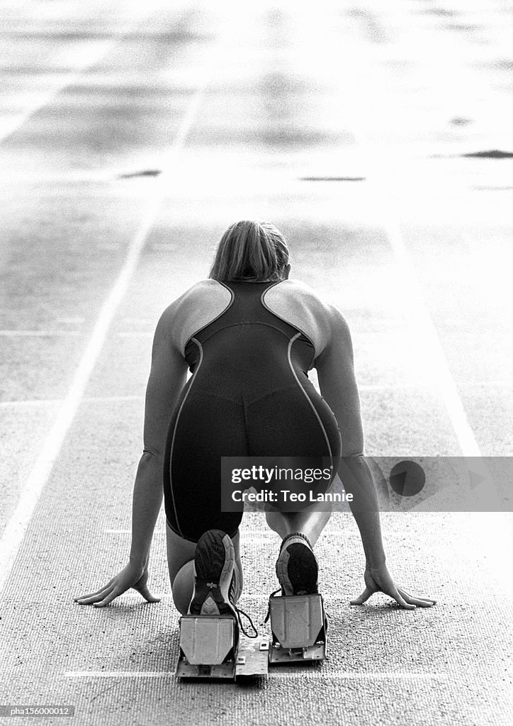 Female runner at starting line, rear view