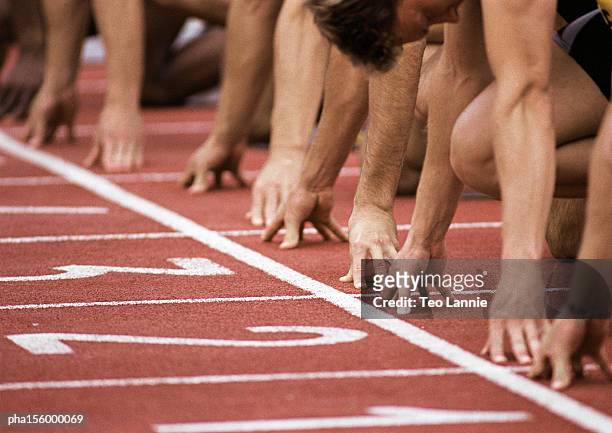 male runners at start of race, close-up - leichtathletik stock-fotos und bilder