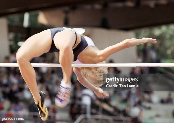 female high jumper clearing bar, low angle view - women's field event 個照片及圖片檔