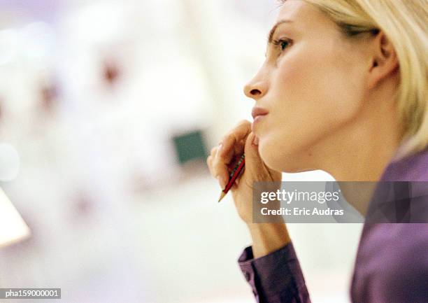 young woman holding pen, side view, out of frame, close-up - out of frame stock-fotos und bilder