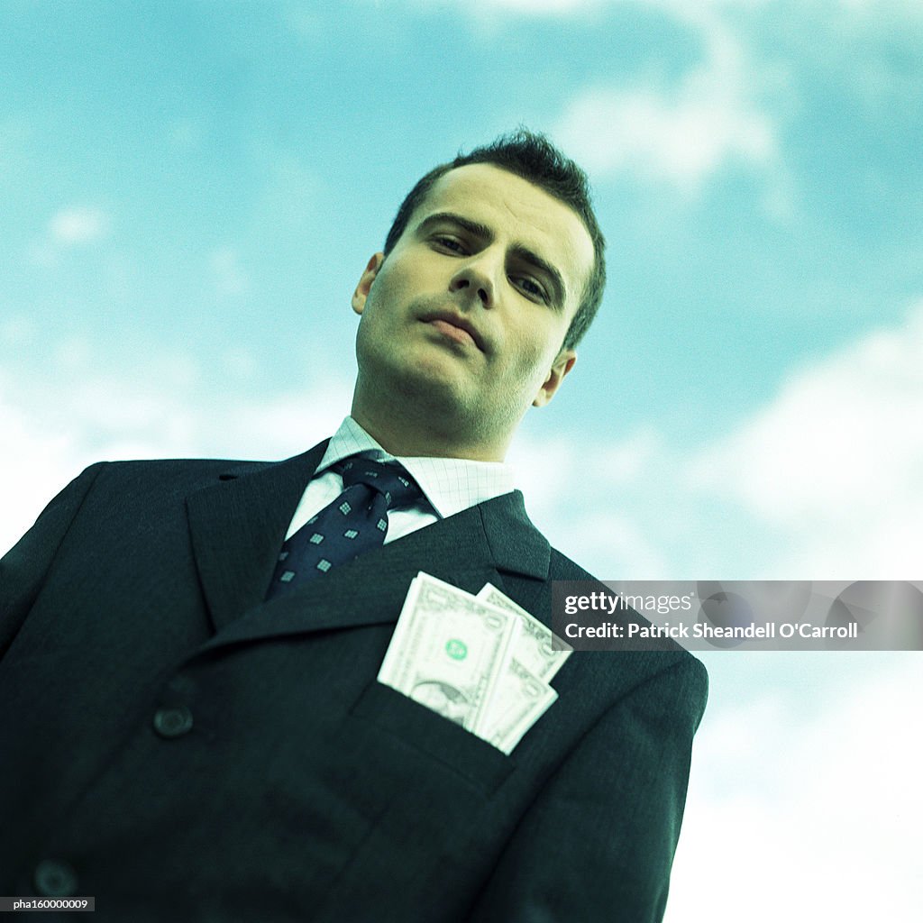 Businessman looking down into camera, low angle view, portrait.
