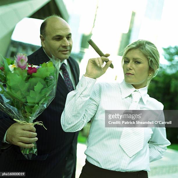 businessman holding flowers, woman holding cigar, portrait. - patrick grant stock pictures, royalty-free photos & images