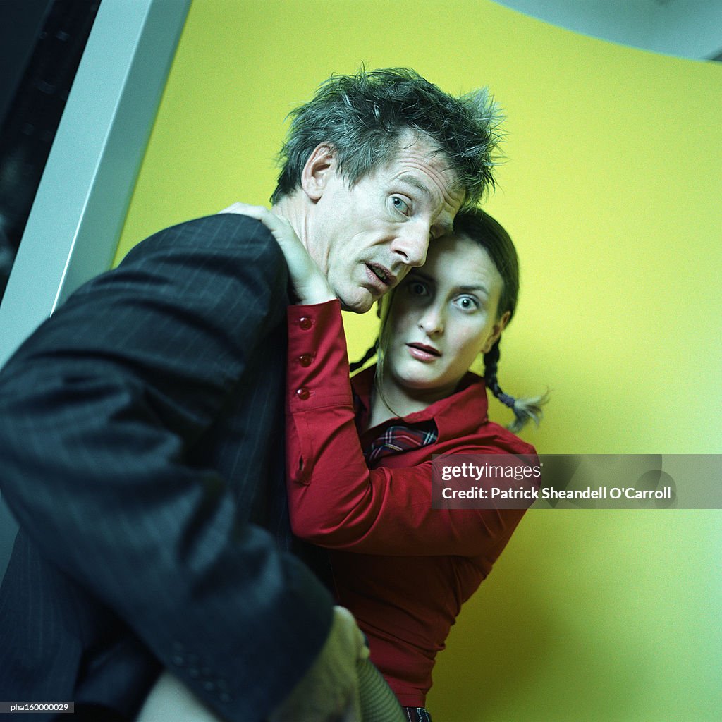 Man and woman looking into camera, man holding woman's leg.