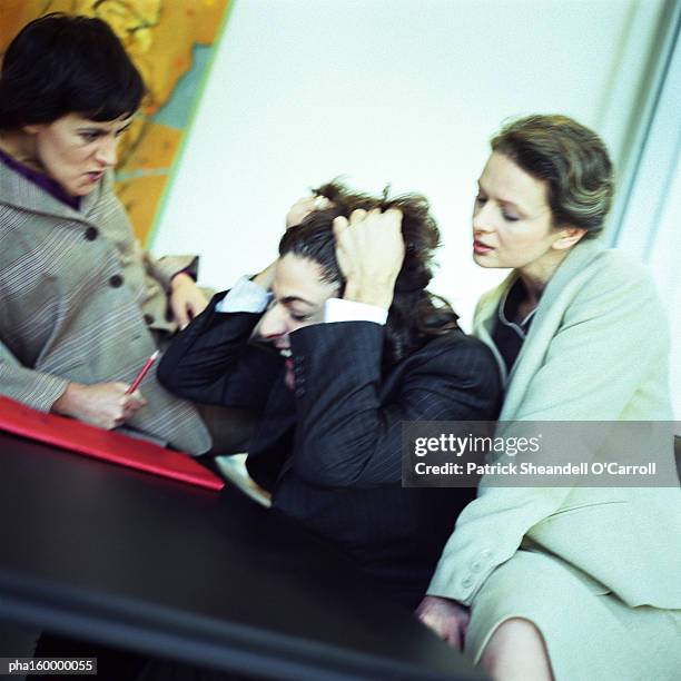 man in suit pulling his hair, two women watching, portrait. - o foto e immagini stock