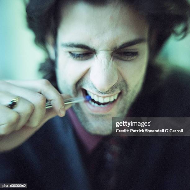 businessman biting pen, portrait. - carroll stock pictures, royalty-free photos & images