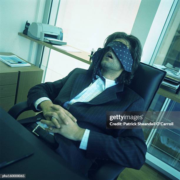 young businessman sleeping at desk, tie covering eyes. - carroll stock pictures, royalty-free photos & images