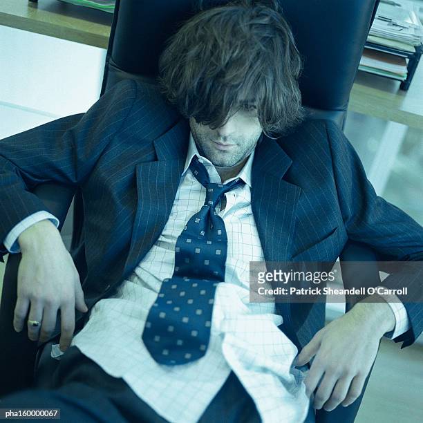 young disheveled man sitting. - carroll stock pictures, royalty-free photos & images