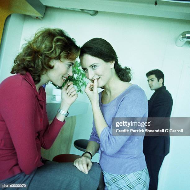 two young women chatting, two men in background. - o foto e immagini stock