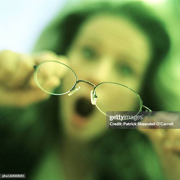 woman holding spectacles, focus on spectacles. - o foto e immagini stock