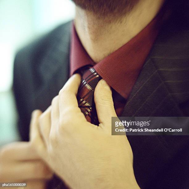close-up of man fixing tie. - o foto e immagini stock