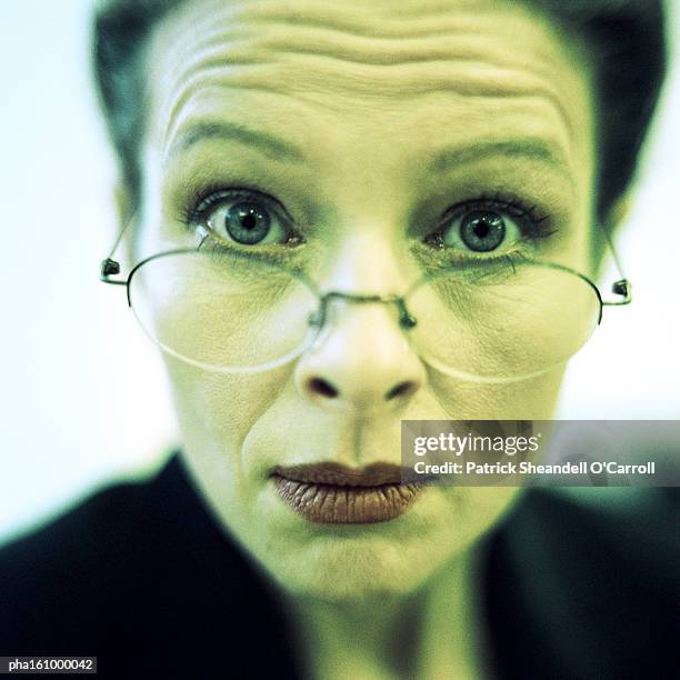 close-up of businesswoman wearing glasses, raising eyebrows, close-up. - o foto e immagini stock