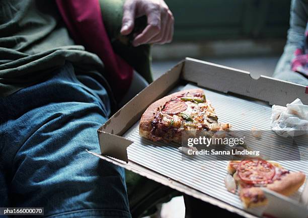 young man with pizza box, two slices of pizza, focus on pizza. - supersensorial fotografías e imágenes de stock