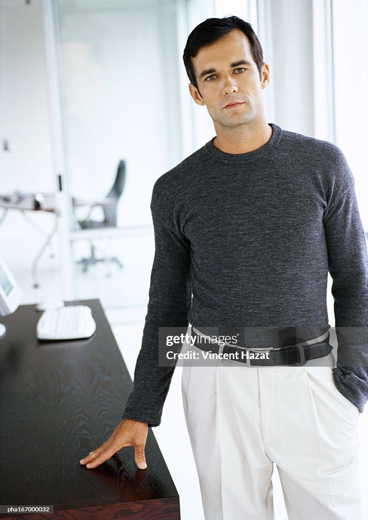 Businessman leaning hand on table