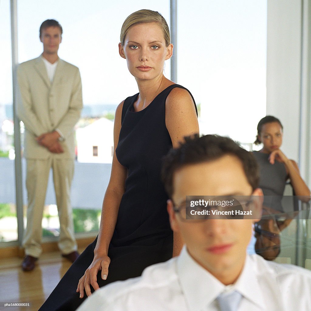 Business people in front of glass wall, portrait, blurred