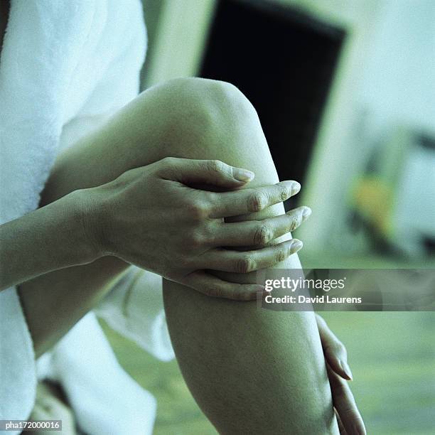 hand on leg with knee up, close-up - laurens foto e immagini stock