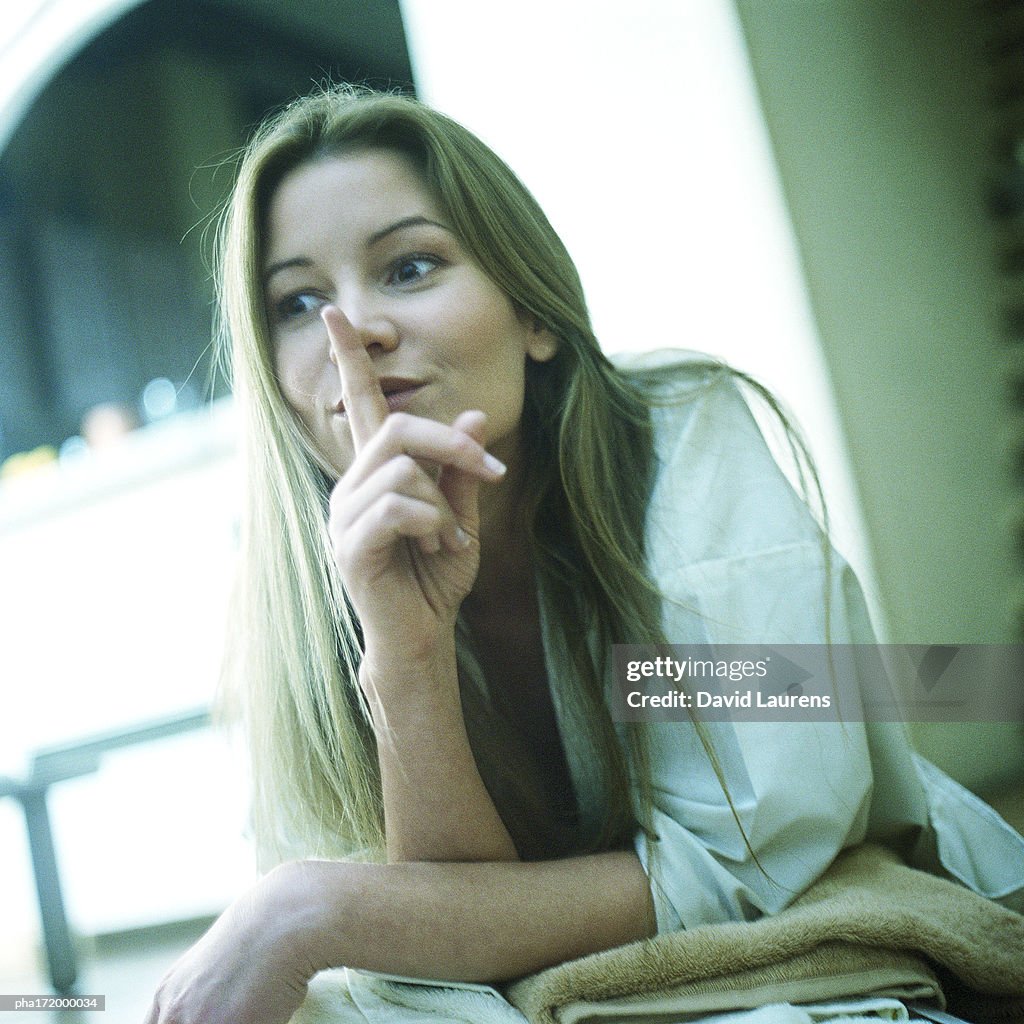 Woman with finger in front of lips