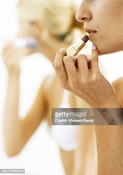 woman putting on lipstick, side view, close-up - make up ストックフォトと画像