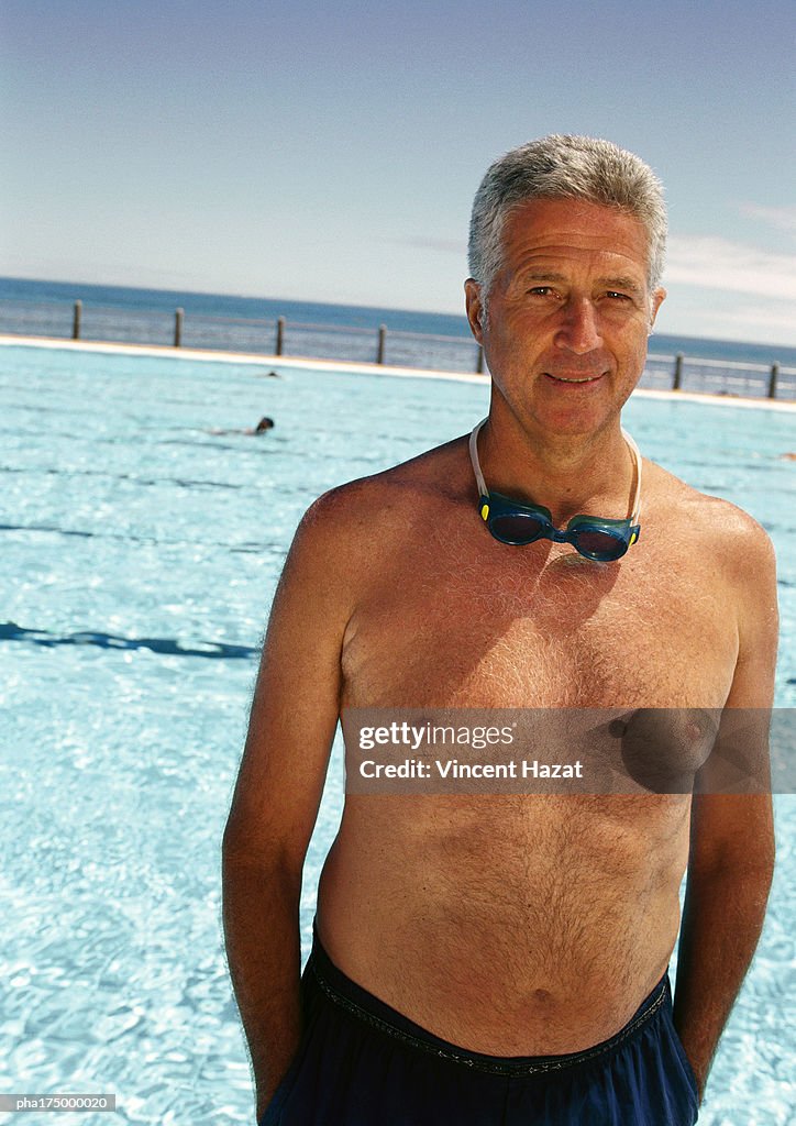 Mature man on side of swimming pool, portrait