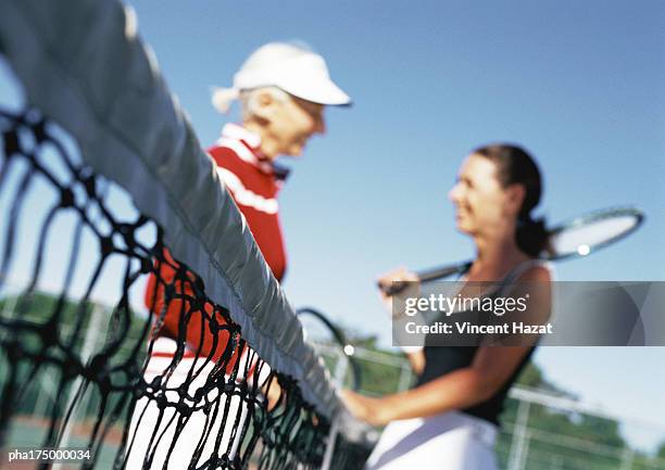 two mature women talking on tennis court, blurred - women talking stock pictures, royalty-free photos & images