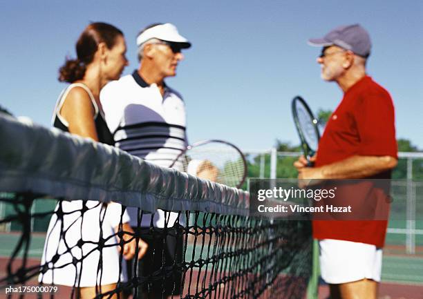 three mature tennis players on court, side view - sports competition format stock pictures, royalty-free photos & images