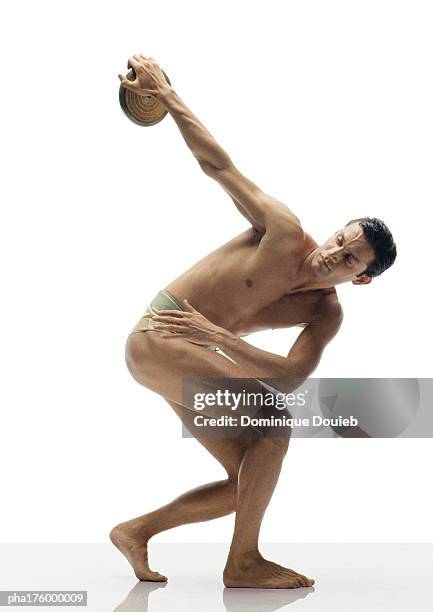 half-nude man preparing to throw discus - men's field event stockfoto's en -beelden