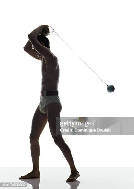 half-nude man preparing to throw hammer, side view - mens field event stockfoto's en -beelden