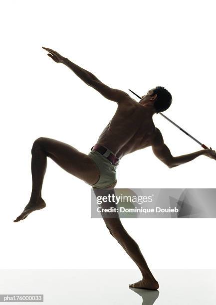 half-nude man throwing javelin, side view - saut et lancer d'athlétisme masculin photos et images de collection