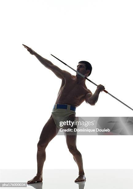 half-nude man preparing to throw javelin, side view - men's field event stock pictures, royalty-free photos & images